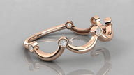A side perspective of the Cloudia rose gold ring lying on a surface, showing its fluid cloud-like silhouette.