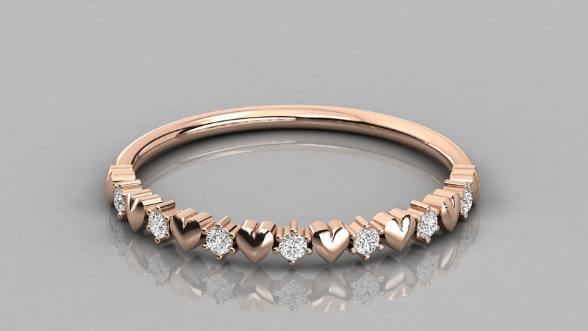 A low-angle perspective view of the Juliette 14k rose gold heart ring, featuring a polished infinity band and seven brilliant lab-grown diamonds.