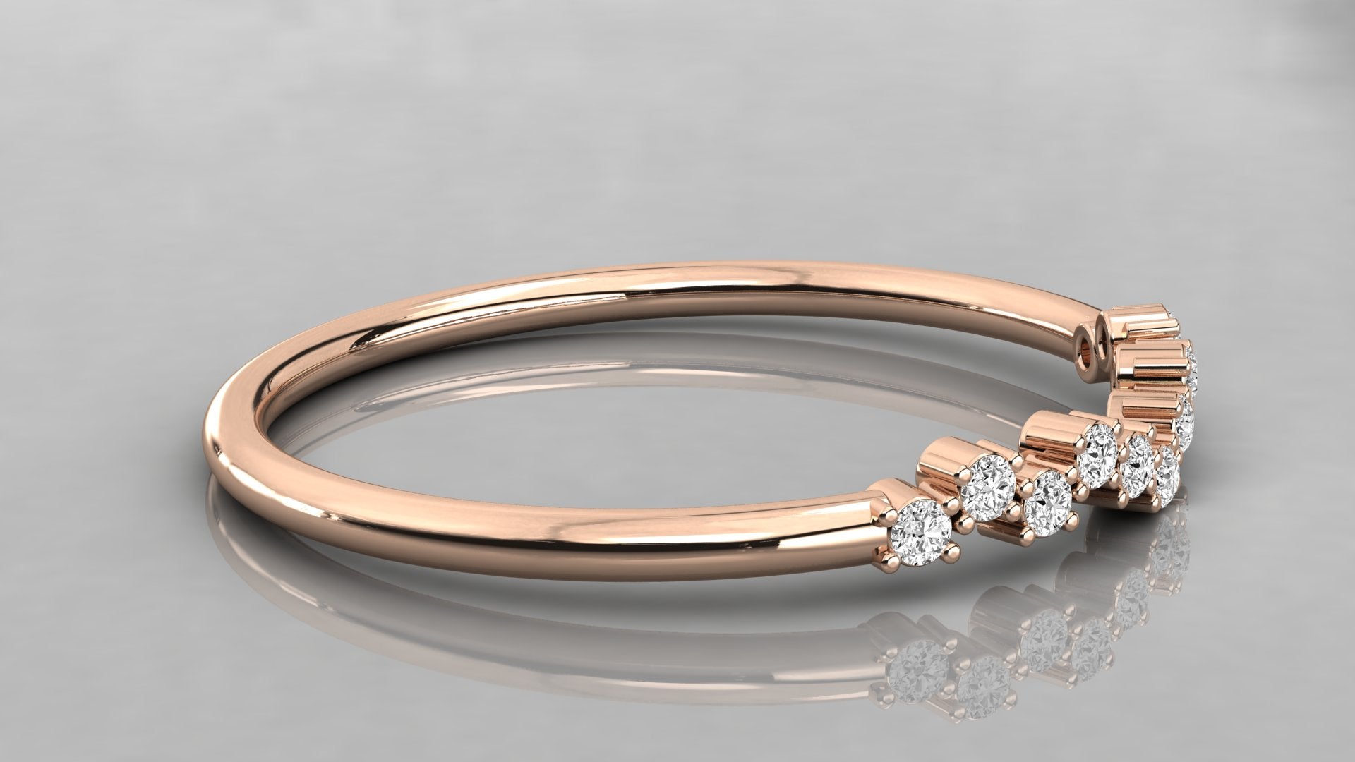 Side perspective of the Lyra rose gold chevron band lying on a surface, highlighting the eleven sparkling ethical diamonds.