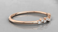 Side perspective of the Lyra rose gold chevron band lying on a surface, highlighting the eleven sparkling ethical diamonds.
