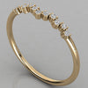 An angled perspective shot of the Lyra 14k yellow gold wishbone ring featuring a radiant row of lab-grown diamonds.