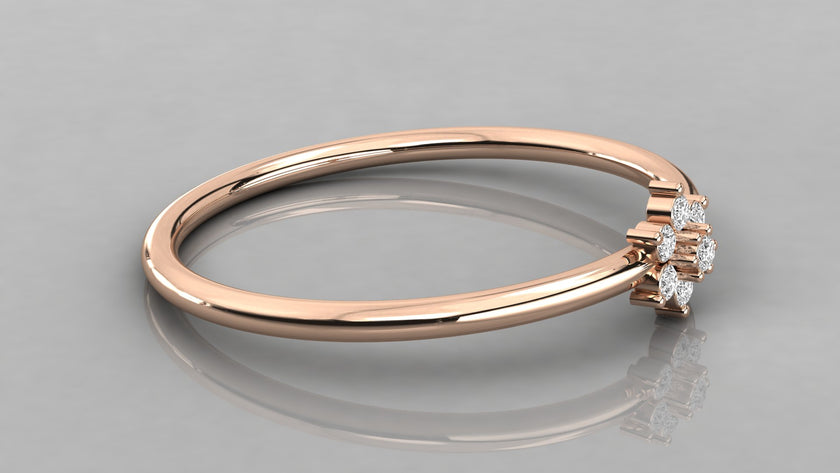 Side-angle view of the Mira rose gold stackable ring lying down, showing the delicate flower petal motif.