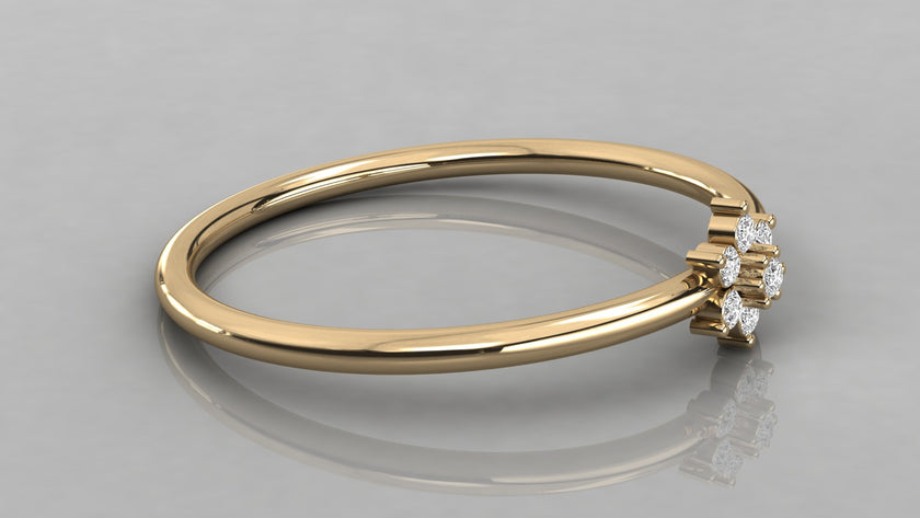 Low-angle lying view of the Mira yellow gold ring highlighting the high-polish finish and petal-like stones.