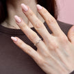 A perspective shot of the minimalist 14K white gold chevron wave ring on a woman's hand, featuring small brilliant-cut diamonds at the peaks of the curved band.